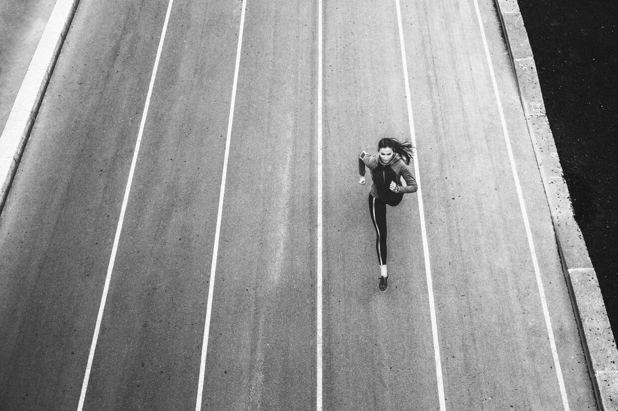 Mujeres corriendo en medio de la carretera.